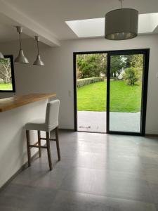 a kitchen with a table and a chair and a window at Belle villa contemporaine & lumineuse plage normandie in Luc-sur-Mer