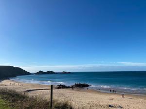 a beach with people walking on the sand and the ocean at Belle villa contemporaine & lumineuse plage normandie in Luc-sur-Mer +11 photos