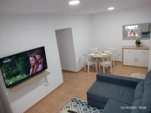 a living room with a couch and a tv on a wall at CASA ROBERTO CANDELARIA,PARKING,AIR,WIFi in Candelaria
