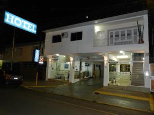 un hôtel avec un panneau devant lui la nuit dans l'établissement Hotel Colon, à Posadas