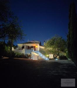 een groot wit huis 's nachts met verlichting bij Monte-Bougainvillea in Faro