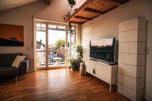 uma sala de estar com uma televisão de ecrã plano e um sofá em VISITALPS moderne Ferienwohnung nähe München u Salzburg em Kolbermoor