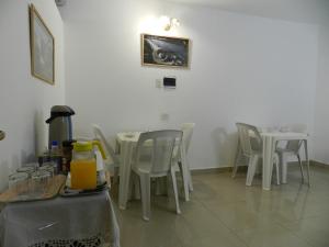 une salle à manger avec des tables et des chaises blanches dans l'établissement Hotel Colon, à Posadas