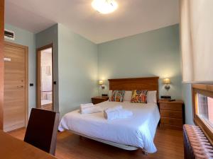 a bedroom with a large bed with white sheets at Hostal Restaurante Torreblanca in Duruelo de la Sierra