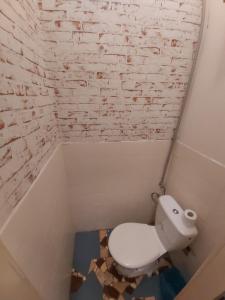 a bathroom with a toilet and a brick wall at Easy Backpacker Old Town in Košice