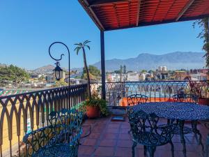 a patio with a table and chairs on a balcony at Hotel Casa Guivá in Oaxaca City