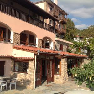 un edificio con mesas y sillas delante de él en Opalio pilio, en Agios Ioannis