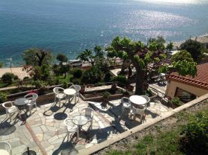 un patio con mesas y sillas con vistas al océano en Opalio pilio en Agios Ioannis Pelio