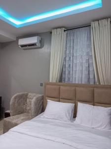 Un dormitorio con una cama con una luz azul encima. en E - Glisters Home, en Warri