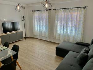 a living room with a couch and a flat screen tv at Arguineguin Beach Lux Solarium Suit in Arguineguín
