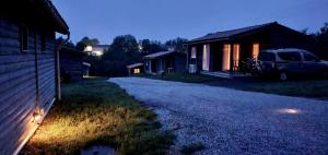 a house with a car parked next to a driveway at LES CHALETS D HERMINE in Montredon-Labessonnié +5 photos