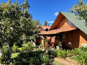 Cabaña de madera con porche y árbol en La Huerta, en Mazamitla