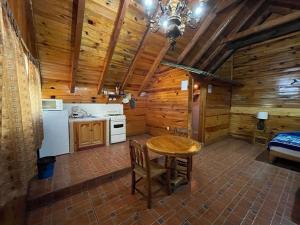 una cocina con mesa en una cabaña de madera en La Huerta, en Mazamitla