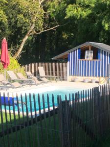 a blue and white shack next to a swimming pool at Domaine d azac in Usson-du-Poitou