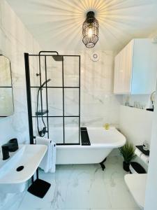 a bathroom with a white tub and a sink and a mirror at Cotswold Chic Retreats "Cloud Nine" 5 Star Chipping Campden-Parking-Garden in Chipping Campden