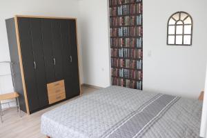 a bedroom with a bed and a book shelf with dvds at Mohnblume, die kleine Oase in Möhnesee