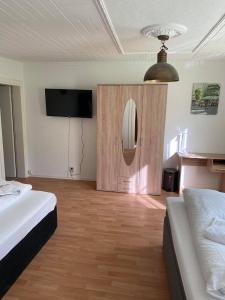 a bedroom with two beds and a flat screen tv at Dorfschenke in Siegen