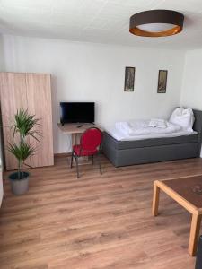 a bedroom with a bed and a desk and a chair at Dorfschenke in Siegen