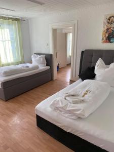 a bedroom with two beds with white sheets at Dorfschenke in Siegen