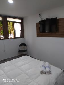 a bedroom with a bed with a tv on the wall at escalinata in Manizales