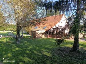 een huis in een tuin met bomen in het gras bij Sauna & Double Jacuzzi intérieur et sous les étoiles 1h30 Paris in Ladon