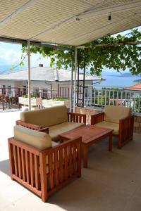 a patio with couches and a wooden table and chairs at Villa Fania in Ohrid