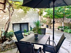 una mesa y sillas con una sombrilla en el patio en Sunrise Apartments, en Niš
