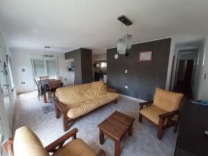 Una sala de estar con un sofá y sillas y una mesa. en La Casita de Thor, en Monte Hermoso 6 fotos más