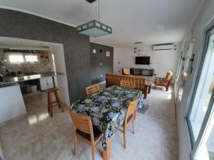 Un comedor y una cocina con mesa y sillas. en La Casita de Thor, en Monte Hermoso