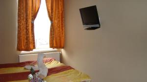 a bedroom with a stuffed animal on a bed with a television at Hotelik Parkowy in Legnica