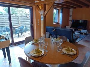 une salle à manger avec une table en bois et des verres à vin dans l'établissement Sauna & Double Jacuzzi intérieur et sous les étoiles 1h30 Paris, à Ladon