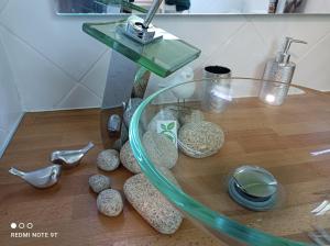 un tavolo in vetro con rocce su un pavimento in legno di Sauna & Double Jacuzzi intérieur et sous les étoiles 1h30 Paris a Ladon