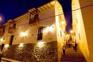 a group of people walking down a street at night at Hotel & Mirador Los Apus in Cusco