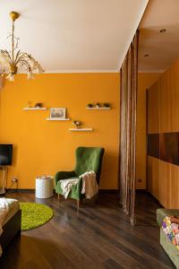 a living room with yellow walls and a green chair at Апартаменты в историческом центре на Репина, 52 in Kaliningrad