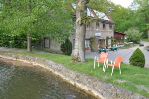 two orange chairs sitting on the grass next to a river at Ferienhaus Caselow 23A in Bergholz