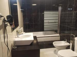 a bathroom with a sink and a toilet and a tub at Casa do Limoeiro - Casa in Golegã