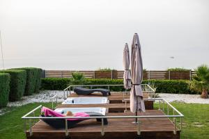 a group of lounge chairs and umbrellas on a deck at Isola Apartments in Xylokastron
