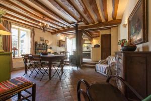a kitchen and living room with a table and chairs at Le Cottage, Maison paysanne au cœur du Vexin in Écos