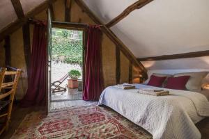 Un pat sau paturi într-o cameră la Le Cottage, Maison paysanne au cœur du Vexin