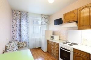 a small kitchen with a stove and a refrigerator at flat-all 151 Kropotkina двухкомнатная квартира с 7 местами рядом с ТРЦ " Галерея Чижова" in Voronezh