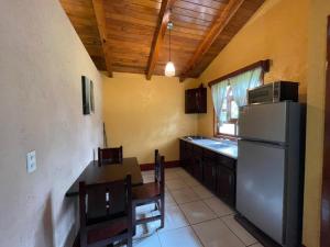 eine Küche mit einem Kühlschrank sowie einem Tisch und Stühlen in der Unterkunft Cabañas Rosy in Mazamitla