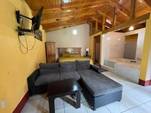 ein Wohnzimmer mit einem Sofa, einem Bett und einer Badewanne in der Unterkunft Cabañas Rosy in Mazamitla