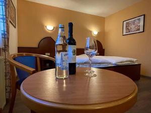 a table with two bottles of wine and a glass at Hotel Haus Hubertus in Elsdorf