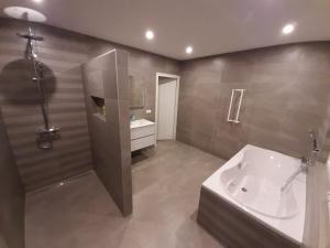 La salle de bains est pourvue d'une douche, d'un lavabo et d'une baignoire. dans l'établissement De droom, à Koningsbosch