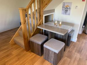 a table with stools in a room with a staircase at Widgeon Bespoke Cabin is lakeside with Private fishing peg, hot tub situated at Tattershall Lakes Country Park in Tattershall