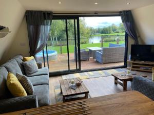 A seating area at Widgeon Bespoke Cabin is lakeside with Private fishing peg, hot tub situated at Tattershall Lakes Country Park
