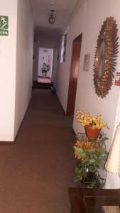 a corridor of a hospital hallway with flowers on the wall at Hospedaje Schell in Lima