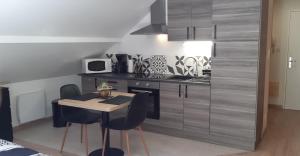 a kitchen with a small table and chairs in a room at Le montagnard in Gérardmer