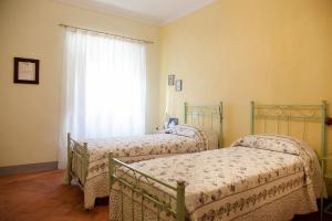 two beds in a room with a window at Appartamento di Lusso in Borgo Storico Toscano in Bibbiena