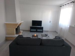 uma sala de estar com um sofá e uma lareira em Charmante maison cosy T2 avec terrasse em Tremblay En France